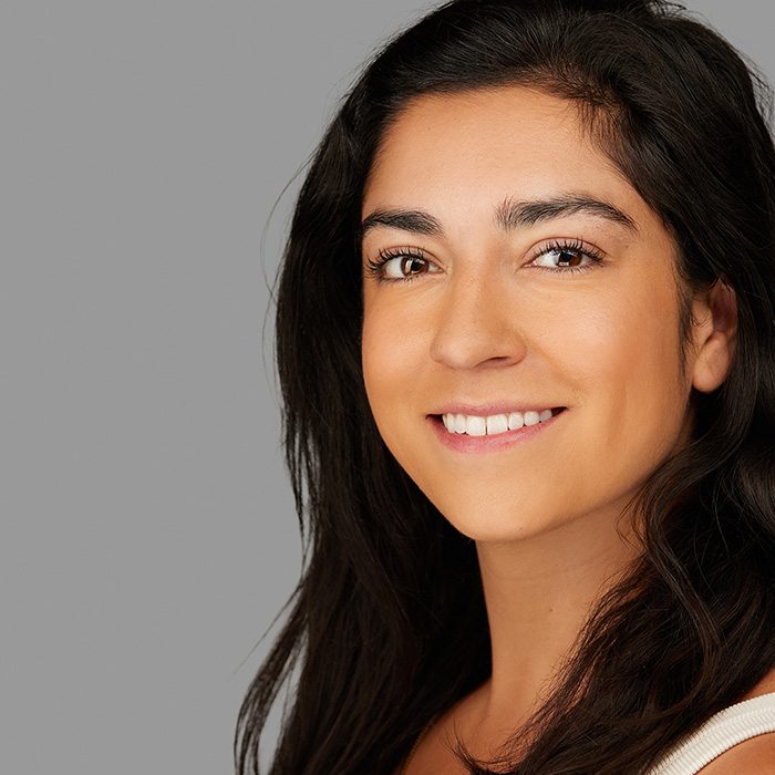 headshot Natalie's hair in the front white traped shirt on gray background by M Carter Photography